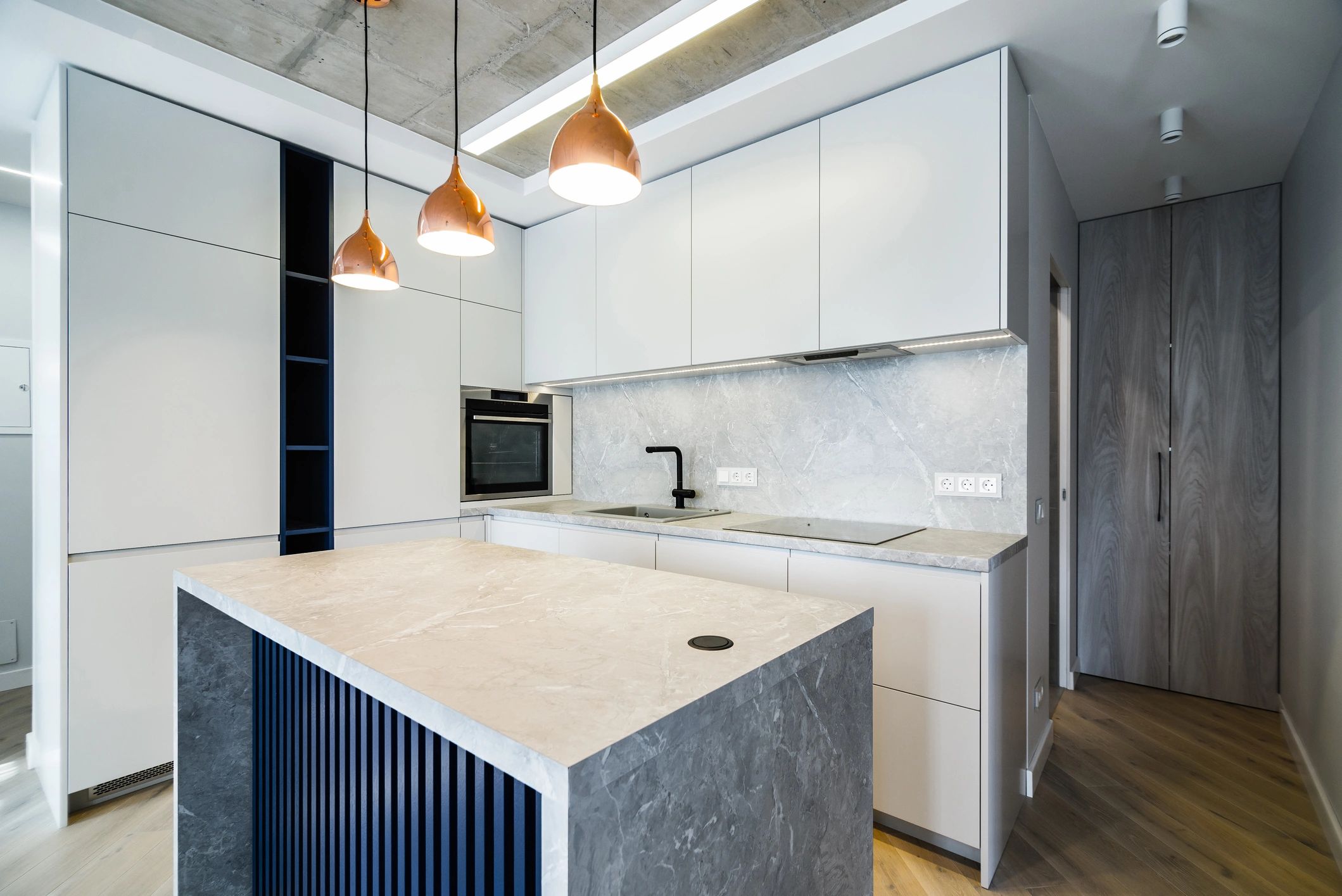 Luxurious, clean, bright modern kitchen with granite-style countertops and a sleek island